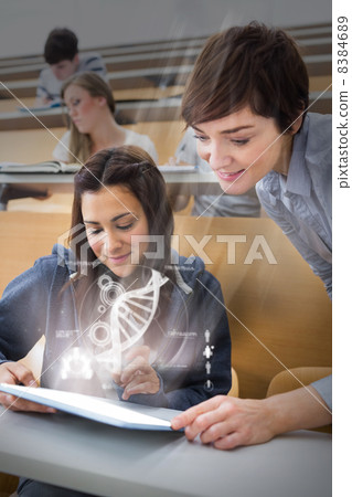 Student and teacher using futuristic hologram to learn biology f 8384689