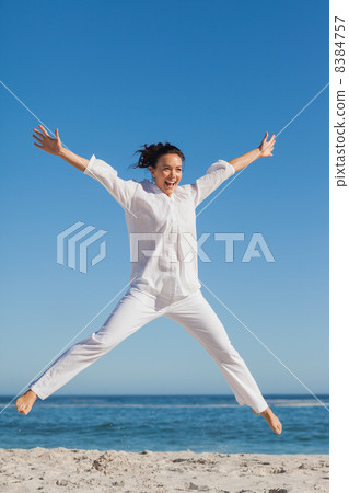 Happy woman jumping on the beach 8384757
