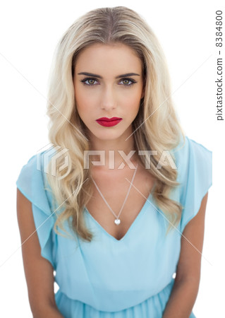 Severe blonde model in blue dress looking at camera 8384800