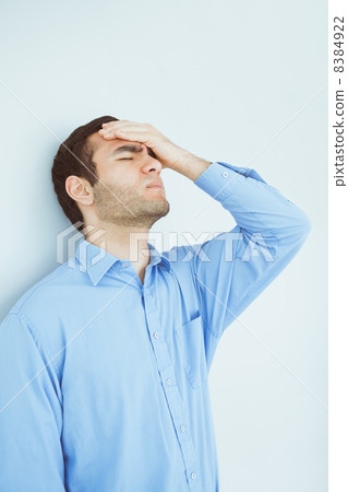 Upset man eyes closed and a hand on the forehead leaning against 8384922