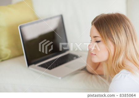Thoughtful woman sitting on floor in front of laptop Thoughtful woman sitting on floor in front of laptop 8385064