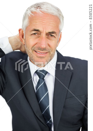 Businessman looking at camera touching his painful neck Businessman looking at camera touching his painful neck 8385221