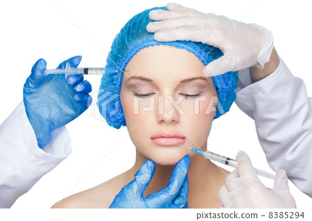 Surgeons making injection on calm blonde 8385294