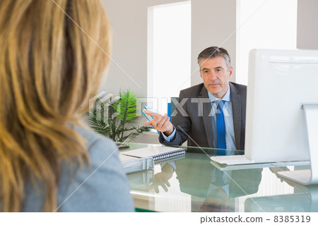 Serious businessman having a discussion with a colleague Serious businessman having a discussion with a colleague 8385319
