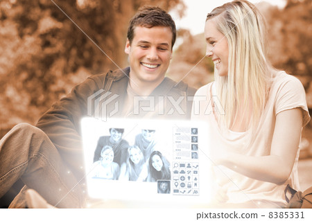 Happy young couple watching photos together on digital interface Happy young couple watching photos together on digital interface 8385331