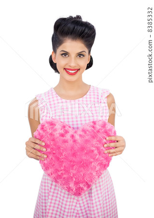 Delighted black hair model holding a pink heart shaped pillow Delighted black hair model holding a pink heart shaped pillow 8385332