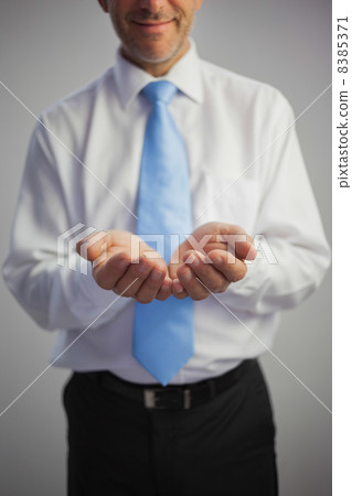 Close up of a pleased businessman joining his hands to the camer 8385371