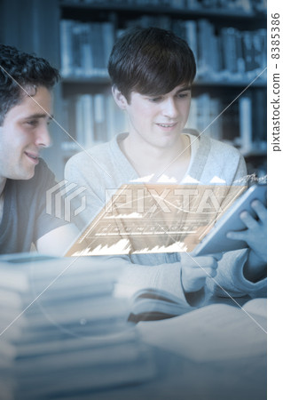 Happy students working together on their digital tablet 8385386