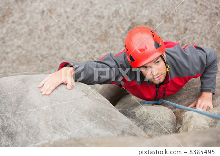 Determined man climbing rock face Determined man climbing rock face 8385495