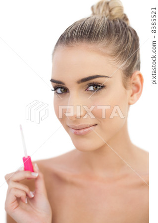 Pleased woman holding a gloss Pleased woman holding a gloss 8385521