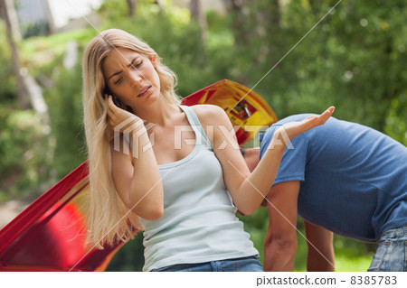 Blonde woman calling for assistance after breaking down 8385783