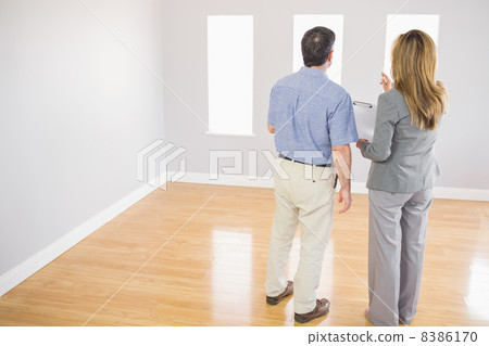 Blonde realtor showing a room to a potential buyer Blonde realtor showing a room to a potential buyer 8386170