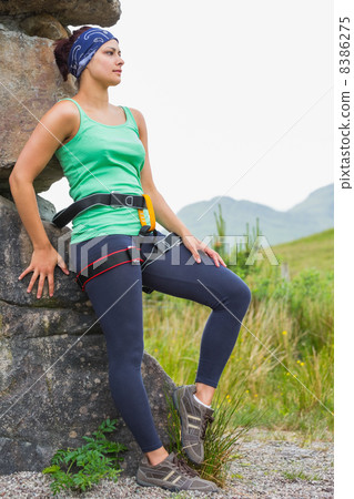 Attractive female rock climber leaning on rock face Attractive female rock climber leaning on rock face 8386275