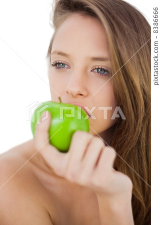Thoughtful brunette model eating an apple Thoughtful brunette model eating an apple 8386666