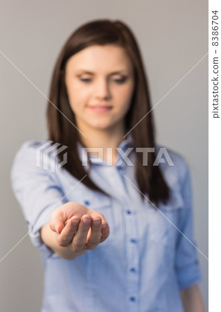 Cheerful pretty brunette presenting her empty hand Cheerful pretty brunette presenting her empty hand 8386704