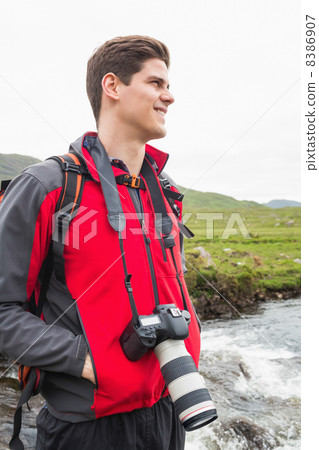 Brunette man on a hike with a camera around his neck 8386907