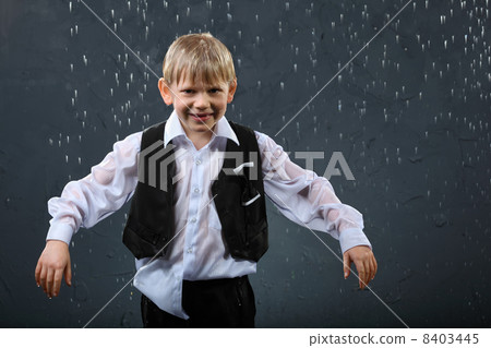 smiling boy dressed in wet white shirt and black vest stands in smiling boy dressed in wet white shirt and black vest stands in 8403445