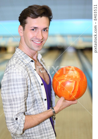 Young happy man wearing in white checkered shirt holds orange ba Young happy man wearing in white checkered shirt holds orange ba 8403511