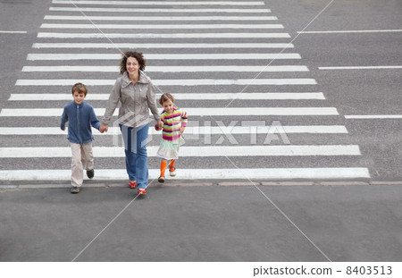 young mother holds hand of his little daughter and son and is go 8403513