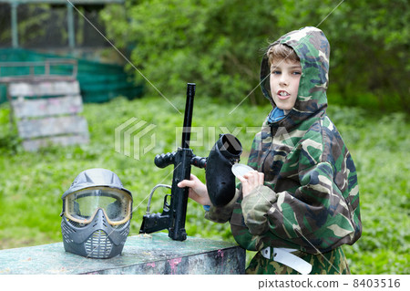 Boy in camouflage with removed protective mask holds a marker wi Boy in camouflage with removed protective mask holds a marker wi 8403516