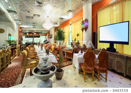 eastern interior of luxury restaurant, potted palms and fountain 8403559