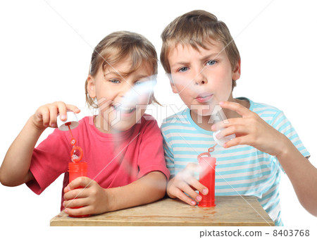 little boy and girl sit at table and blow bubbles isolated on wh little boy and girl sit at table and blow bubbles isolated on wh 8403768