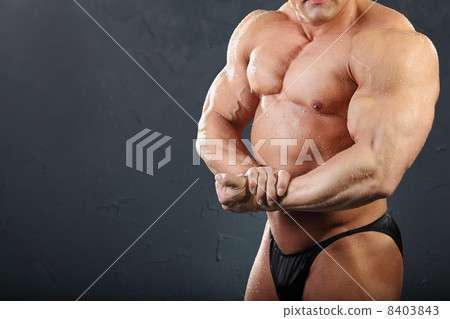 Powerful chest and hand muscles of undressed tanned wet bodybuil 8403843