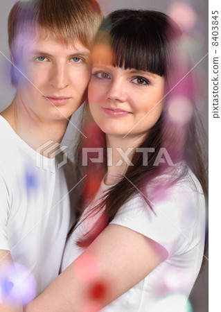 Young man and woman dressed in white shirts stand behind transpa 8403845