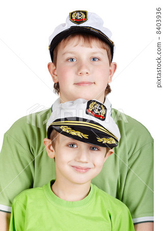Portrait up of two boys in green T-shirts and white sea peak-cap 8403936
