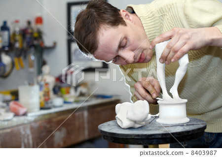 Sculptor works in the studio on a fragment of plaster sculpture. Sculptor works in the studio on a fragment of plaster sculpture. 8403987