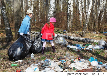 Back of brother and sister with black bags collect trash in park 8404114