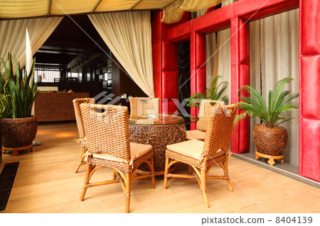 Beautiful wicker chairs and table in empty classy restaurant 8404139