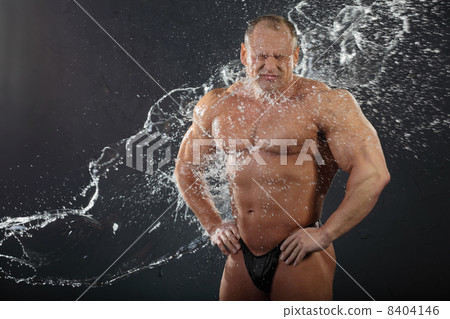 Water flows on undressed tanned bodybuilder with wrinkled face. 8404146