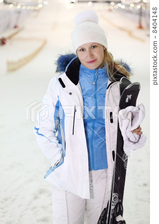 Young woman dressed in white sports clothes stands with skis and Young woman dressed in white sports clothes stands with skis and 8404148