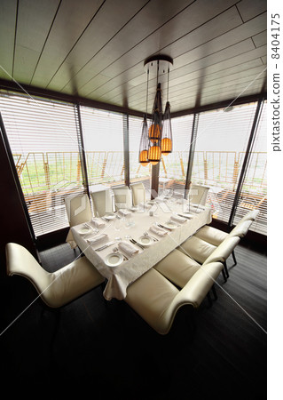 table with white tablecloth and serving and ten white chairs in 8404175