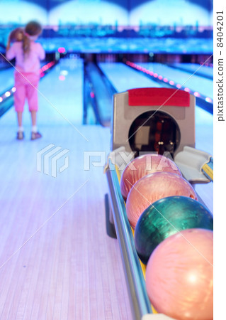 Girl prepares to throw ball in bowling; Focus on number of color Girl prepares to throw ball in bowling; Focus on number of color 8404201