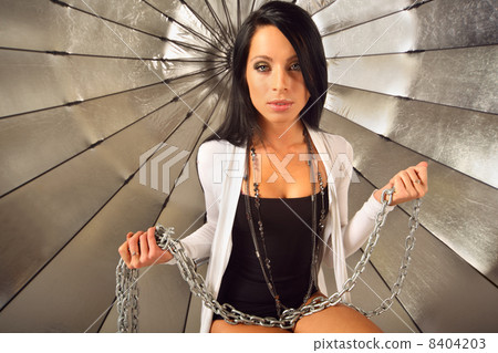 beautiful brunette girl sits with chain near big silver umbrella 8404203
