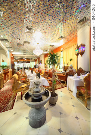 eastern interior of beautiful restaurant, potted palms and fount 8404266