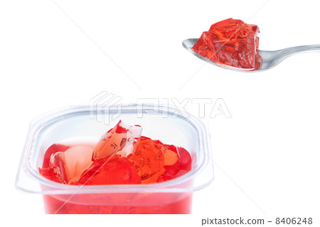Spoon full of red gelatin. Against the background of the package Spoon full of red gelatin. Against the background of the package 8406248