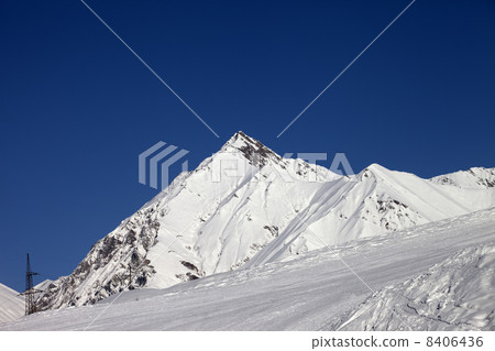 Ski slope and blue clear sky at sunny day Ski slope and blue clear sky at sunny day 8406436