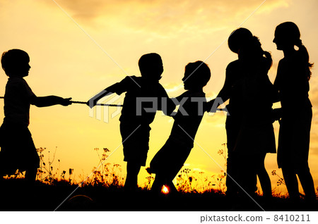 Silhouette, group of happy children playing on meadow, sunset, summertime 8410211