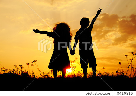 Silhouette, group of happy children playing on meadow, sunset, summertime 8410816