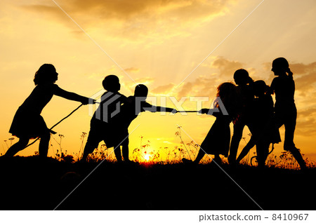 Silhouette, group of happy children playing on meadow, sunset, summertime 8410967