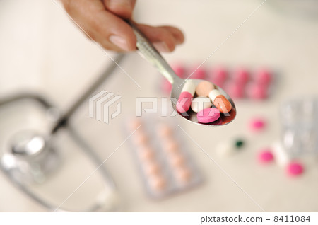 Doctor with pills in spoon 8411084