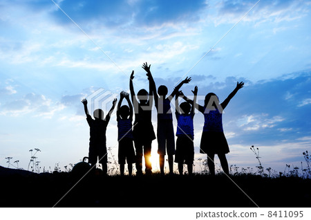Silhouette, group of happy children playing on meadow, sunset, summertime 8411095