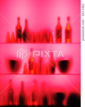 Abstract blurred vine bottles and glasses on shelf, pink color 8411462