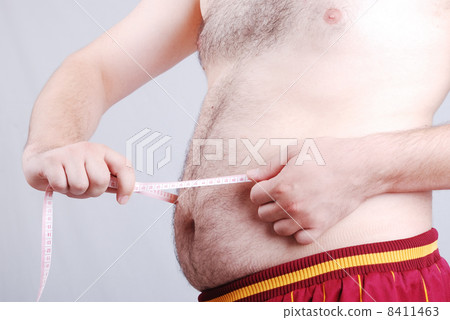 Fat man holding a measurement tape against white background 8411463