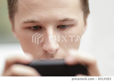 young man lokking in the screen of mobile phone young man lokking in the screen of mobile phone 8414365