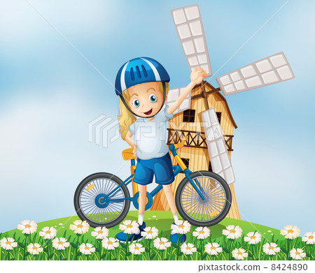 A female biker standing at the hilltop with a windmill A female biker standing at the hilltop with a windmill 8424890