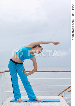 Happy woman dressed in blue sports suit stands on cruise liner d 8431954